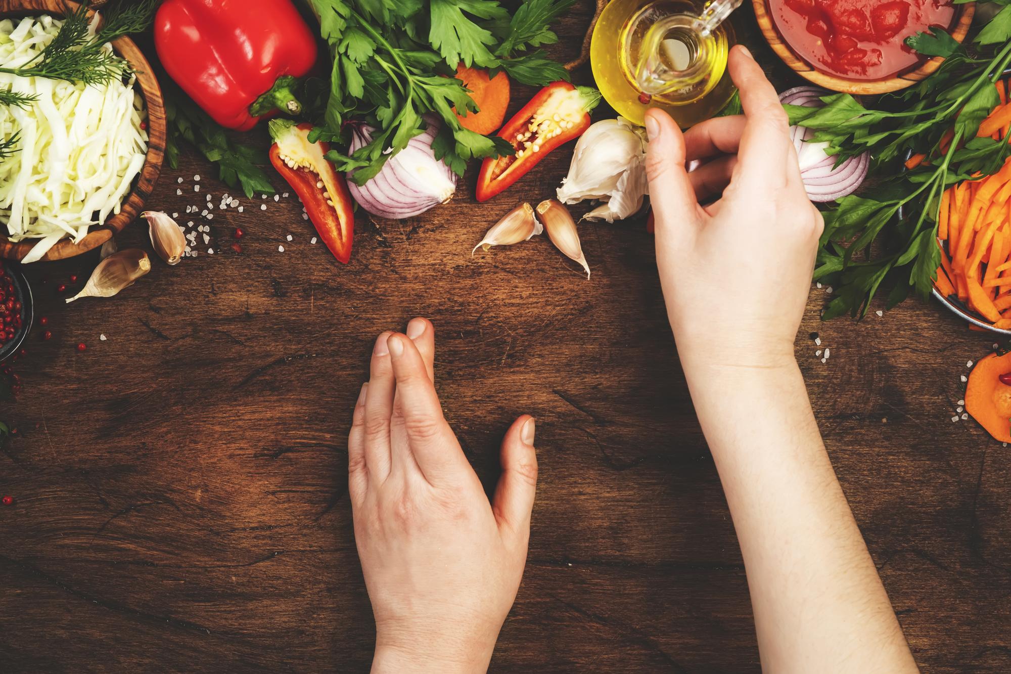 Close-up of hands seasoning roasted vegetables